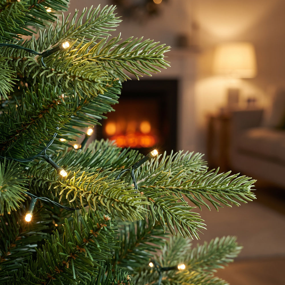 Close up of realistic fir branches and warm white LED lights