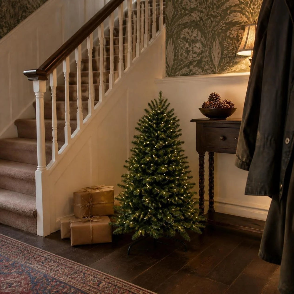 90cm pre-lit Christmas tree standing at the foot of the stairs in a hallway